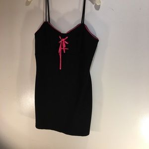 A black mini dress with pink trim and ribbon